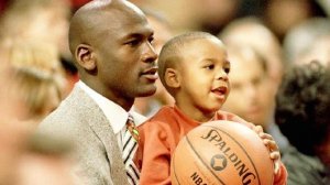 Retired Chicago Bulls basketball star Michael Jordan holds his son Marcus, November 6, 1993, as they watch a Bulls game in Chicago.